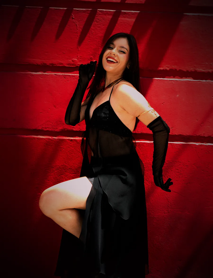 Ana Sofía bailando frente a un muro rojo