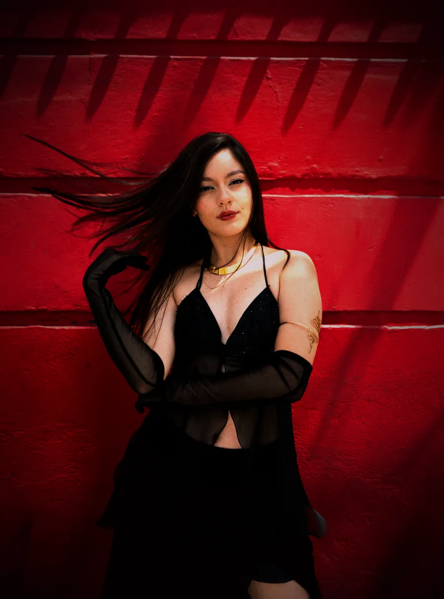Ana Sofía con el cabello en movimiento frente a un muro rojo